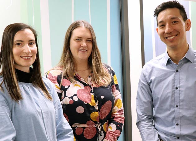 Three members of the Service Model Transformation team stand together smiling.