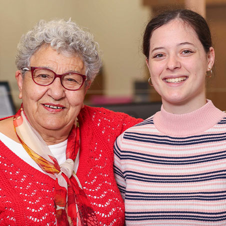 Client and staff member stand together smiling